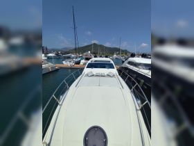 A clear view of a yacht docked at a marina, showcasing its sleek design and surrounding boats against a picturesque backdrop.