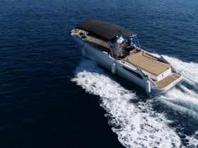 A sleek speedboat glides through the deep blue waters, showcasing its elegant design and performance capabilities.