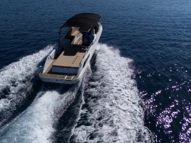 A stunning aerial view of a speedboat cruising through clear blue waters, showcasing its sleek design and dynamic movement.
