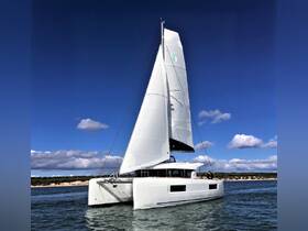 A stunning catamaran sailing gracefully on the water, showcasing its sleek design and vibrant sails against a clear blue sky — perfect for sailing enthusiasts and charter adventures.