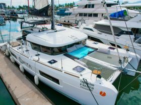 A sleek catamaran named 'Laguna Goo' docked in a marina, showcasing its spacious deck and modern design — perfect for luxury sailing experiences.