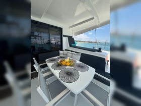 A beautifully arranged dining area inside a yacht, featuring a table set with fresh fruit, perfect for enjoying meals while cruising on the water.