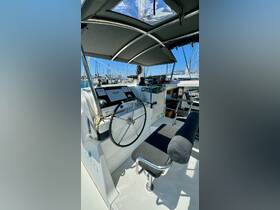 A well-equipped helm area of a Lagoon catamaran, showcasing the steering wheel and console, perfect for navigating the open waters.