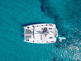 A stunning aerial view of a catamaran cruising through crystal-clear waters, showcasing guests enjoying the sun and sea — perfect for adventure seekers.