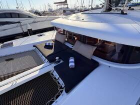 A cozy lounge area on a catamaran, featuring comfortable cushions and towels, perfect for relaxing while enjoying the marina views.