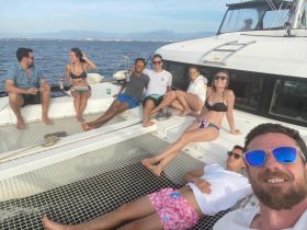 A lively group enjoys a sunny day on a yacht, relaxing and celebrating together — perfect for social gatherings and memorable outings on the water.