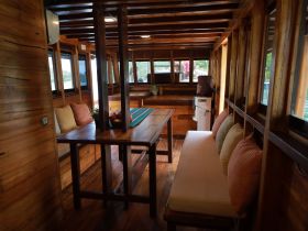 Interior view of a cozy boat cabin featuring a dining area and comfortable seating, perfect for relaxing during a day on the water.