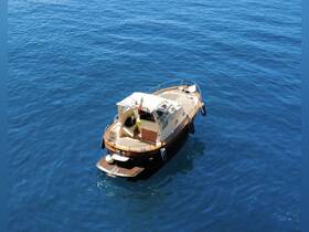 Aerial view of a charming boat anchored in deep blue waters, showcasing its elegant design and inviting deck space.