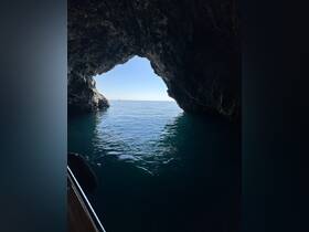 A stunning view from inside a cave looking out towards the calm ocean, showcasing the natural beauty of coastal landscapes — perfect for adventure seekers and nature lovers.