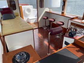 Interior view of a stylish boat cabin featuring comfortable seating and a well-equipped helm, perfect for relaxing or navigating the waters.