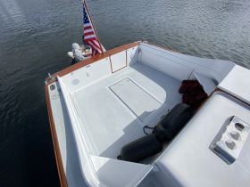 A clean and spacious view of the interior deck of a boat, showcasing the helm area and seating, ideal for relaxing while cruising on the water.