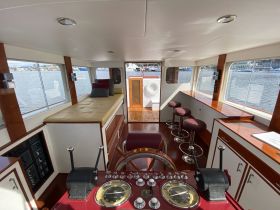 A well-appointed helm area inside a boat, featuring comfortable seating and a clear view of the water, perfect for navigating and relaxing.