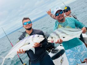 A group of anglers proudly display their catch while fishing on the open water, showcasing the thrill of a successful fishing trip.