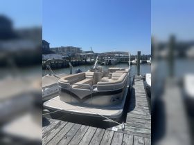 A beautiful pontoon boat docked at the marina, showcasing its spacious seating and sleek design — perfect for leisurely outings on the water.