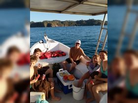 A joyful family enjoys snacks aboard a boat, creating memorable moments on the water with delicious fruits and laughter.