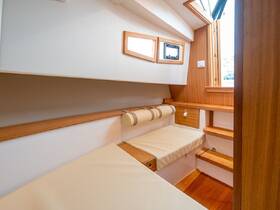 A cozy cabin interior showcasing comfortable seating and wooden finishes, perfect for relaxing on a boat.
