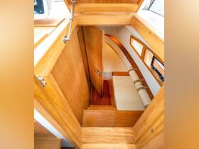Interior view of a cozy boat cabin featuring warm wooden finishes and comfortable seating, perfect for relaxing during a day on the water.