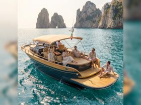 A lively group enjoys a day on a stylish boat, surrounded by stunning rock formations and clear waters — perfect for unforgettable adventures with friends.