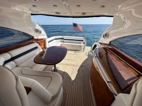 A stylish interior view of a yacht's cabin featuring comfortable seating and a polished table, perfect for relaxing while enjoying the ocean views.