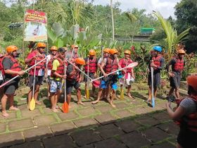 A group of adventurers prepares for a rafting experience, equipped with paddles and safety gear, showcasing the excitement of outdoor water activities.