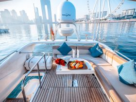 A beautifully arranged dining setup on a yacht featuring a platter of fresh fruits and pastries, perfect for a luxurious day on the water.