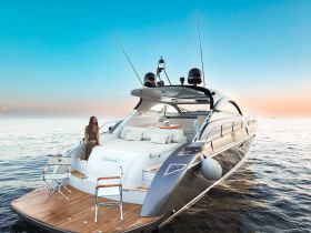 A woman enjoys a serene moment on the deck of a luxury yacht, surrounded by calm waters and a stunning sunset — perfect for upscale boating experiences.