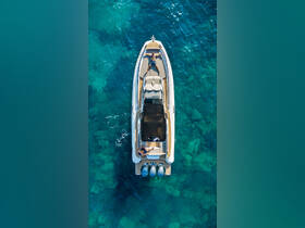 Aerial view of two individuals relaxing on a sleek boat in crystal-clear waters, perfect for showcasing leisure and adventure on the open sea.
