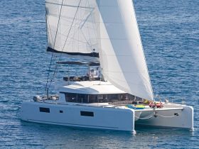 A sleek catamaran sails through clear waters, showcasing its elegant design and spacious layout, perfect for luxury charters and sailing adventures.