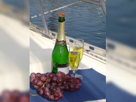 A beautifully arranged display of sparkling wine and fresh grapes on a boat, perfect for a relaxing day on the water.