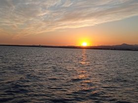 A serene sunset over calm waters, capturing the tranquil beauty of a boating experience — perfect for evening cruises and relaxation on the water.