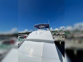 A clear view of the exterior of a boat with a blue canopy, docked and ready for adventure under a bright blue sky.