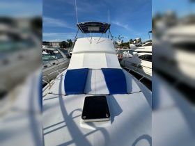 A clear view of the deck of a yacht, featuring blue sun pads and a spacious layout, perfect for relaxing on the water.