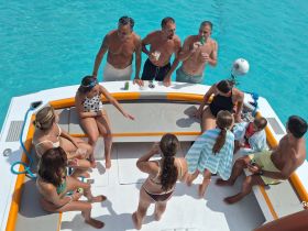 A lively group enjoys a fun day on the water, sharing drinks and laughter aboard a boat, perfect for family gatherings and celebrations.