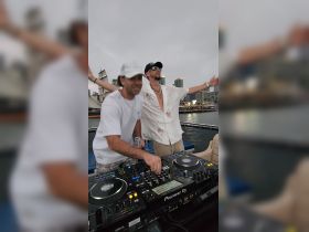 Two DJs perform on a boat, creating a lively atmosphere for a celebration on the water — perfect for party cruises and music events.