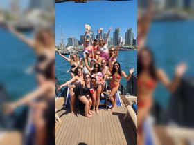 A lively group of friends celebrates on a boat, enjoying drinks and fun in the sun — perfect for summer parties and memorable outings on the water.