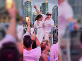 A lively celebration on a boat with guests dancing and enjoying drinks, capturing the essence of a fun night out on the water.