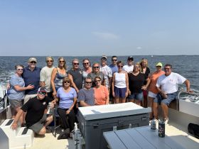 A lively group of friends gathers on a boat, enjoying a sunny day on the water — perfect for celebrations and memorable outings.