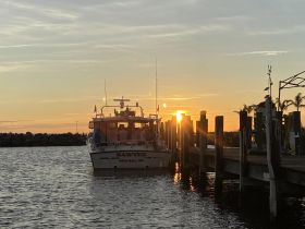 The 'Sawyer' boat is docked at sunset, creating a picturesque scene perfect for evening cruises and gatherings on the water.
