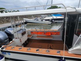 Interior view of a boat's helm and seating area, showcasing a well-equipped space for passengers and crew.