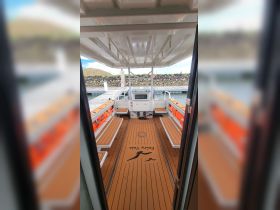 Interior view of a boat's cabin featuring ample seating and a helm, ideal for comfortable outings on the water.