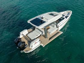 Aerial view of a sleek speedboat cruising through clear waters, showcasing its modern design and spacious deck — perfect for thrilling adventures on the water.