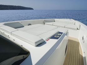 The interior of a sleek boat features luxurious lounge seating, perfect for relaxing on the water.
