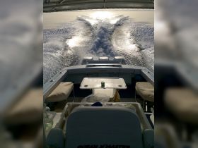 A view of the helm and seating area inside a boat, showcasing the sleek design and inviting space for relaxation while cruising on the water.