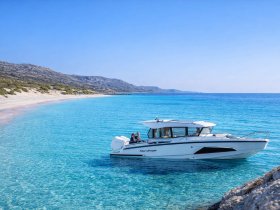 A sleek boat is anchored in crystal-clear waters, showcasing a stunning coastal landscape — perfect for exploring secluded beaches and enjoying the sun.