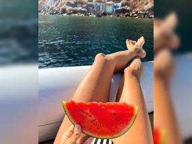 A relaxing moment on a boat with a slice of fresh watermelon, perfect for enjoying sunny days on the water.