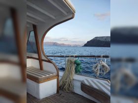 Interior view of a boat showcasing comfortable seating and neatly arranged ropes, perfect for relaxing while enjoying the scenic ocean views.