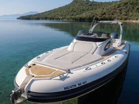 A sleek speedboat docked in crystal-clear waters, showcasing its elegant design against a serene backdrop of lush greenery and mountains.
