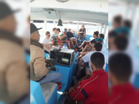 A lively group enjoys drinks and conversation aboard a boat, creating a fun atmosphere perfect for social outings on the water.