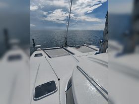 A serene view of a catamaran deck with sparkling waters in the background, perfect for showcasing the beauty of sailing adventures.