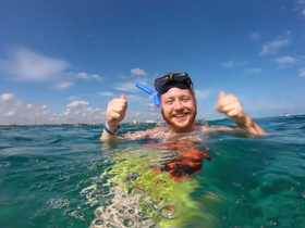 A joyful snorkeler gives a thumbs-up while enjoying the clear ocean waters, capturing the excitement of underwater adventures.